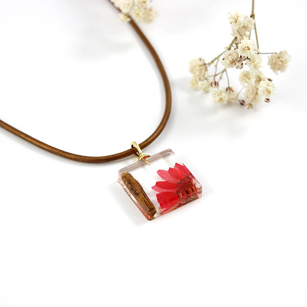 Colgante de resina con flor e inclusiones de madera