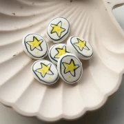 Cuenta ovalada de cerámica 19,5x16 mm - Motivo estrella - Blanco - Amarillo x1