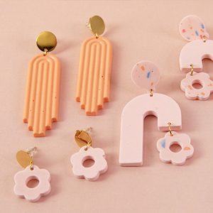 boucles d'oreilles pendantes oranges et roses pâles et créoles en forme de fleurs roses effet terrazzo