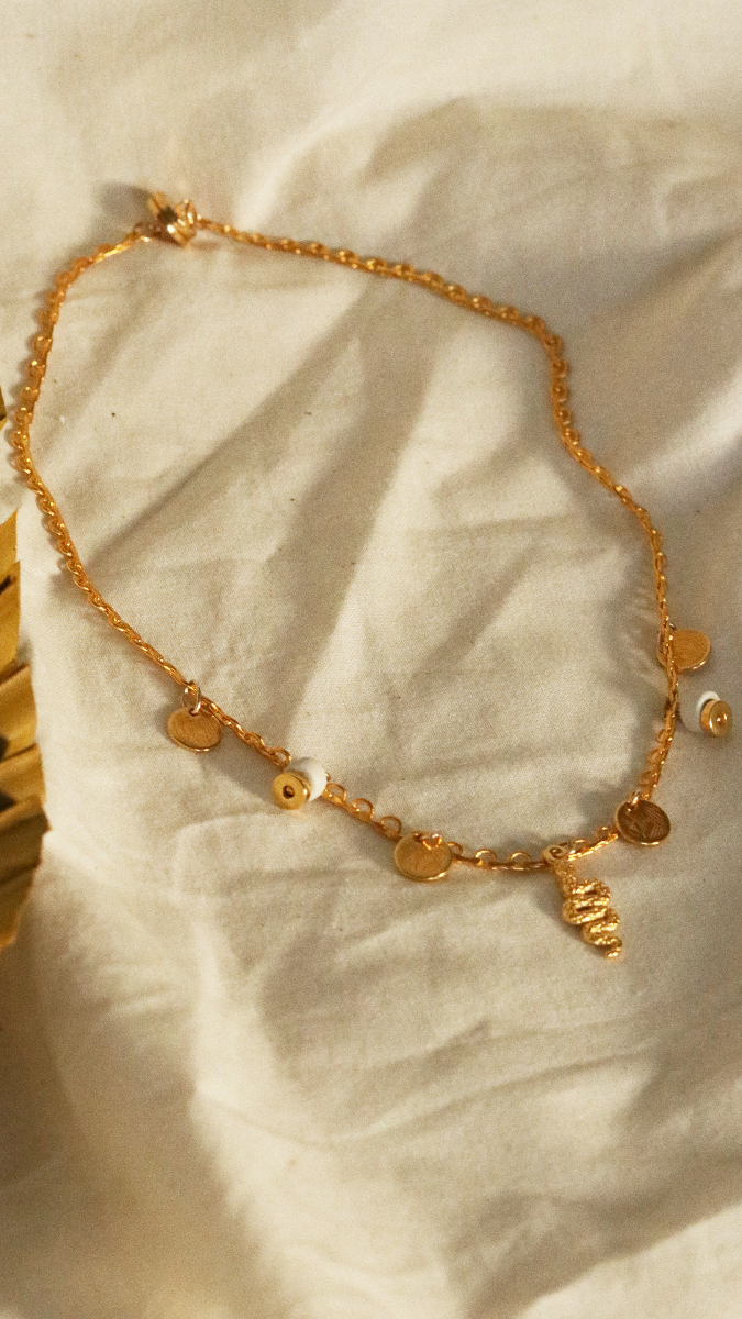 Esquema Collar de Charlotte bañado en oro con abalorios de serpiente de oro fino, lentejuelas y cuentas heishi de cerámica.