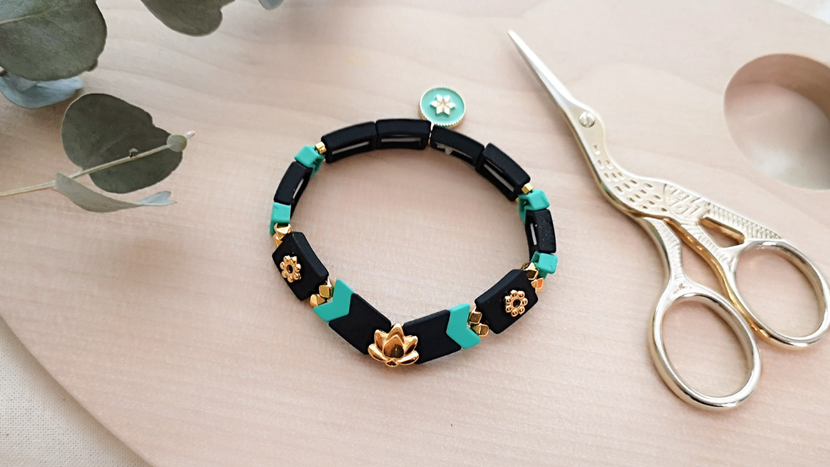 Brazalete elástico con cuentas de efecto de goma de espina de pescado y una capa intermedia de loto dorado.