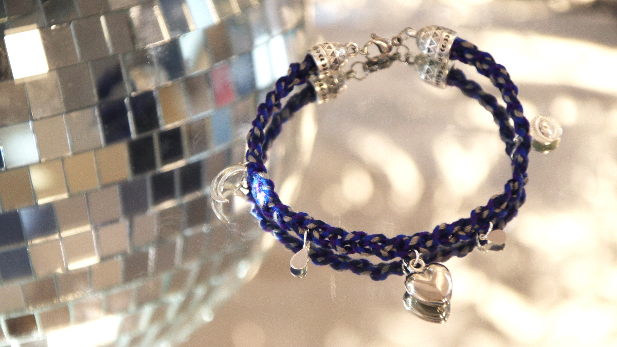 Pulsera grigri plateada con charms e hilo de algodón trenzado azul