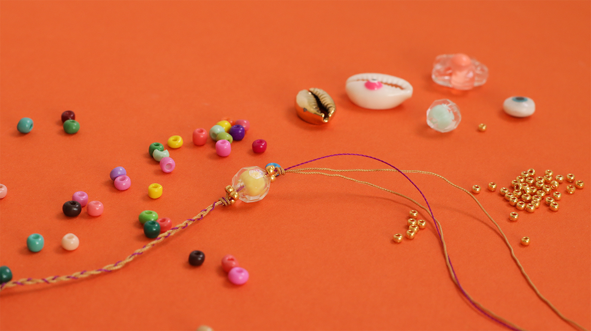 Pulsera de verano con conchas de cauri, cuentas de semillas y ojo : Paso 2