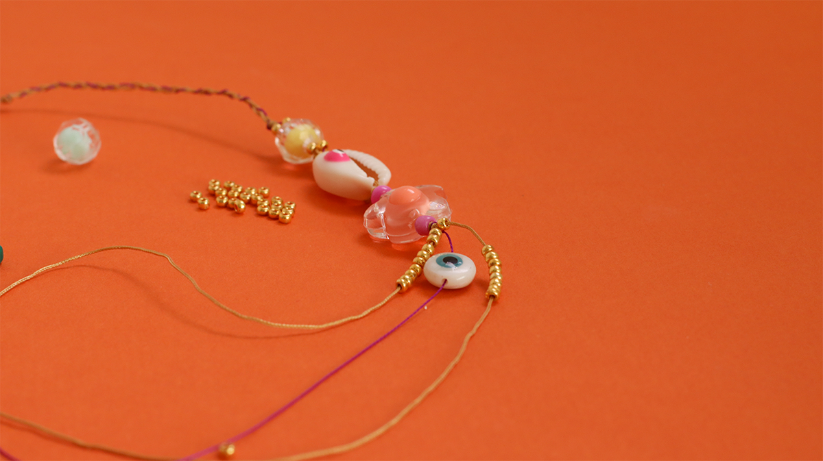 Pulsera de verano con conchas de cauri, cuentas de semillas y ojo : Paso 3