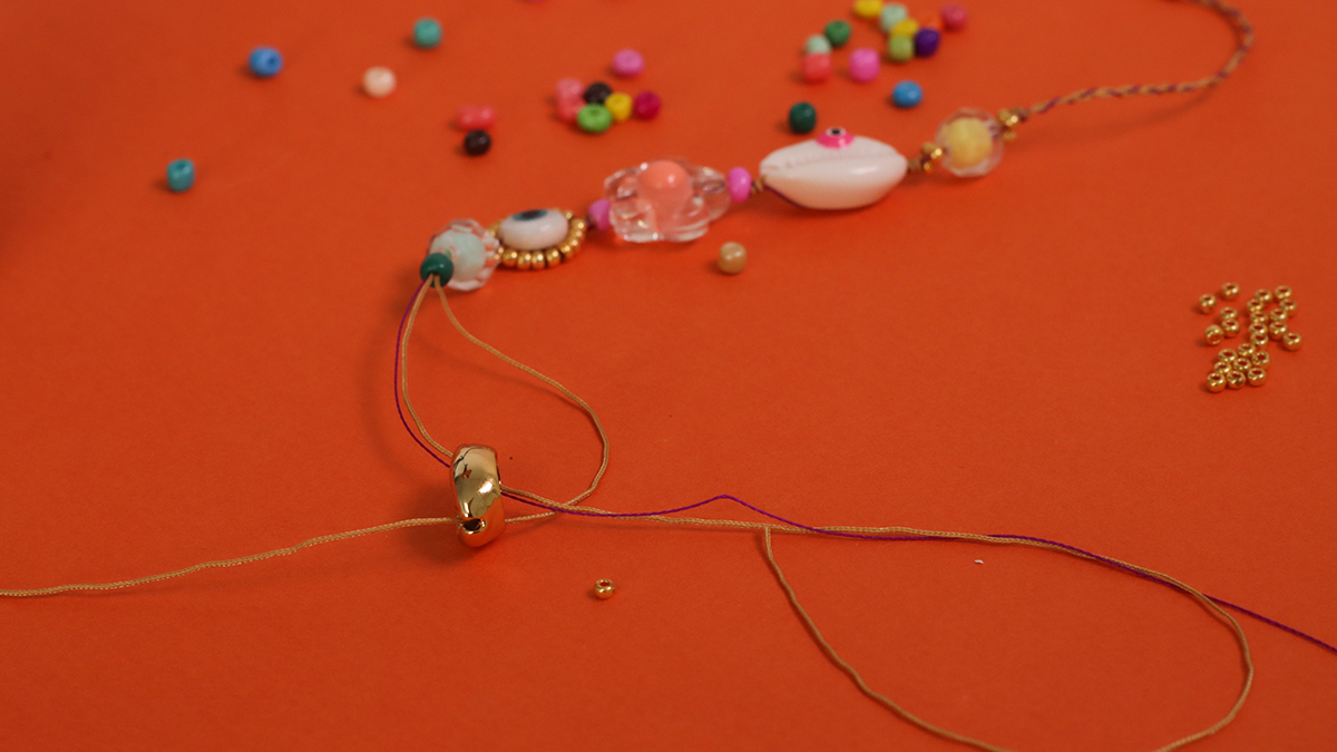 Pulsera de verano con conchas de cauri, cuentas de semillas y ojo : Paso 4