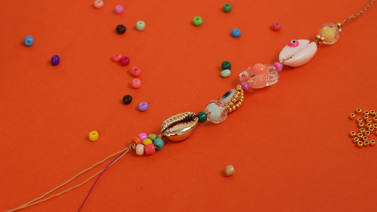 Pulsera de verano con conchas de cauri, cuentas de semillas y ojo : Paso 5