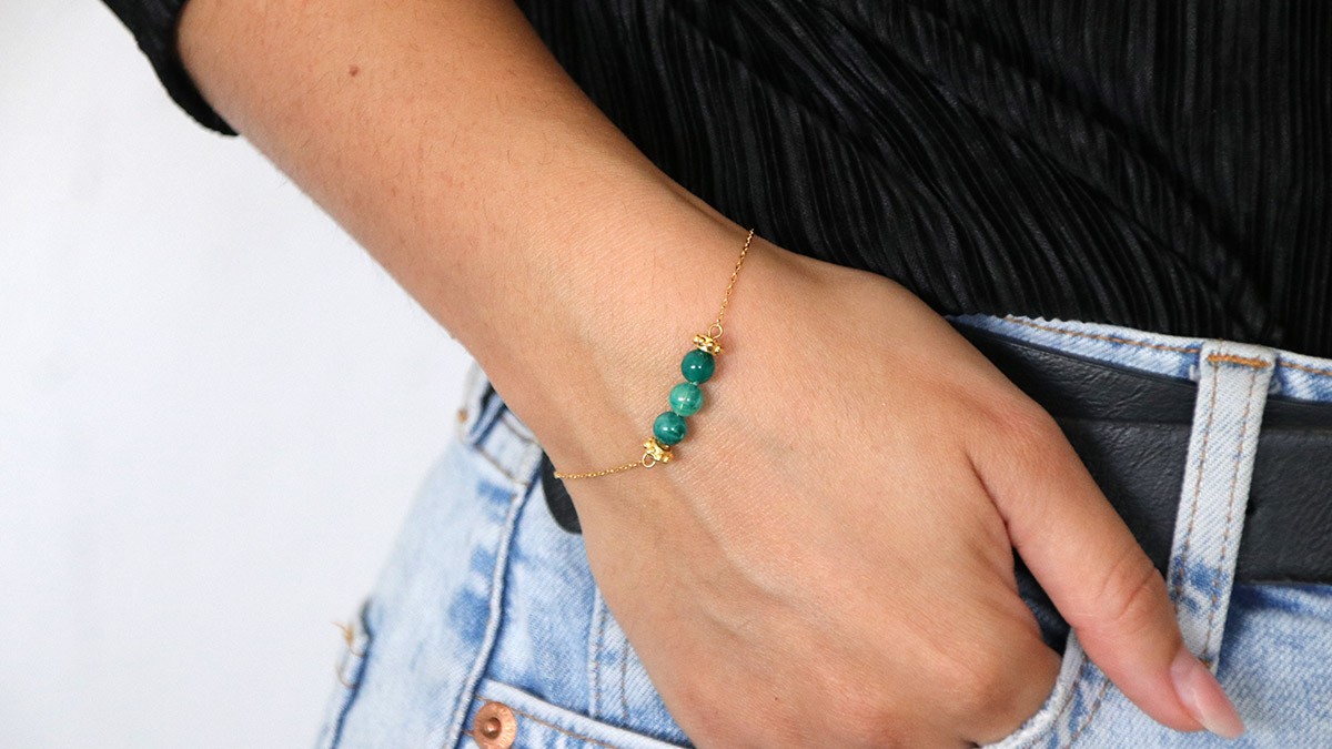 Pulsera sencilla con cuentas verdes en el centro de una cadena