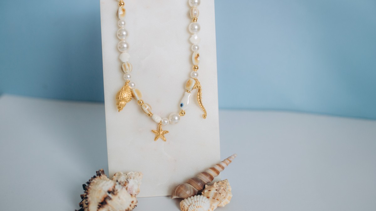 Collar de cuentas de cerámica, cuentas de nácar y dijes marinos