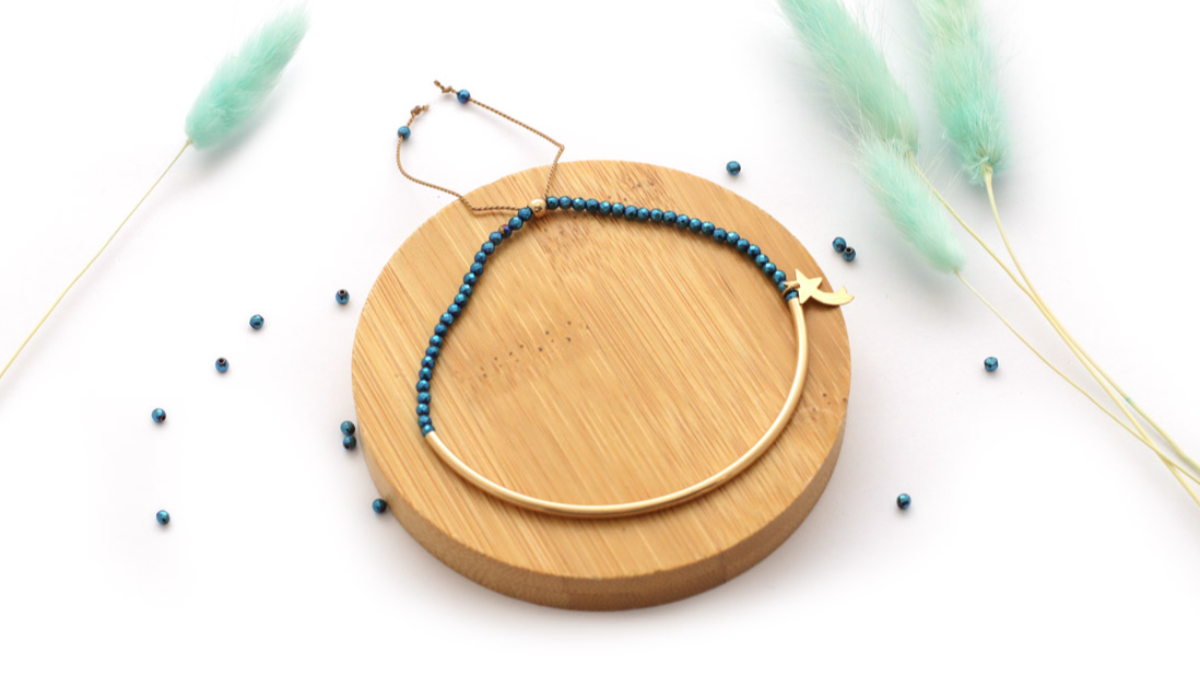 Pulsera de media anilla rellena de oro con hematites azules y estrella fugaz.