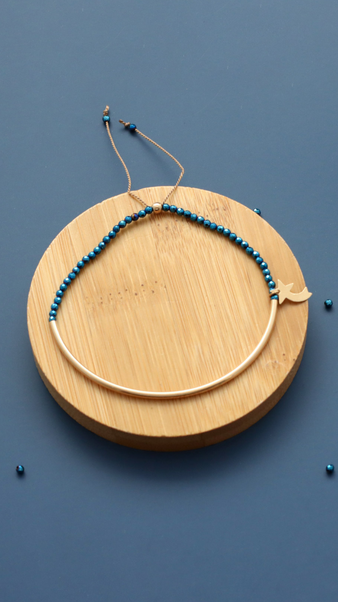 Esquema Pulsera de media anilla rellena de oro con hematites azules y estrella fugaz. Esquema Pulsera de media anilla rellena de oro con hematites azules y estrella fugaz.
